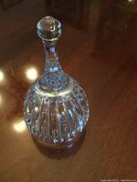 View of crystal bell showing faceted body and handle with round faceted top knob.