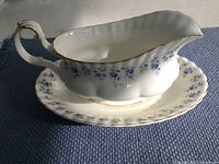 Full view of the two-piece Royal Albert Memory Lane gravy bowl set showing the serving bowl sitting on the oval tray with floral pattern and gold accents.