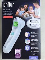 Photo of Braun no touch thermometer packaging front showing the device with digital display and key features including color-coded fever guidance and no touch measurement.