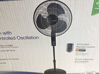 Photo of the pedestal fan with remote control shown on packaging.
