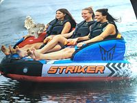 Three riders seated on the HO Striker tube in water
