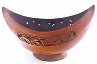 Side view of vintage wooden bowl showing detailed hand carved leaf and vine design with crescent shape