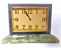 Front view of vintage mantel clock showing rectangular dial, dark frame, and green alabaster base.