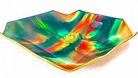 Angled close-up of tray showcasing vibrant enameled colors and wavy edges with gold trim.