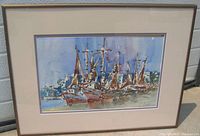 Framed watercolor painting signed by Jaime Oates showing a boat harbour scene with several boats and buildings in the background.