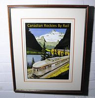 Front view of framed vintage Canadian Pacific Railway advertising print titled 'Canadian Rockies By Rail' depicting a passenger train and mountainous landscape.