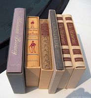 Photo showing the spines of six hardcover books in slipcases: Madame Bovary, The Way of All Flesh, History of New York, Candide, and two volumes of The Histories by Shakespeare.