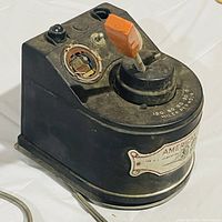 Side view of the black American Flyer train power controller showing the orange lever, dial with speed markings up to 120 miles per hour, and worn front label.