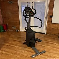 Front view of Bodyguard exercise climber, black and gray with console and foot pedals visible