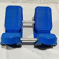 Top view of blue calf stretcher showing two textured foot platforms connected by metal rods with heel supports