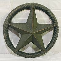 Cast iron five-pointed star with twisted rope circular border, dark green paint with wear