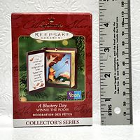 Front view of the Hallmark Keepsake Ornament box showing the product name, series, and image of the open book ornament featuring Winnie the Pooh.
