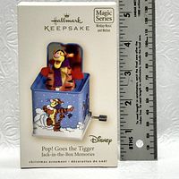 Photo of the Hallmark Keepsake Magic Series ornament box featuring Tigger in a jack-in-the-box with measurement scale for size reference.