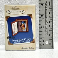 Photo of Little Rain Cloud Winnie the Pooh Hallmark Keepsake Ornament in original box with a ruler for scale.