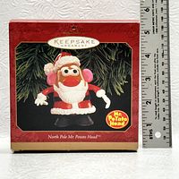 Front view of the ornament box showing Mr. Potato Head dressed as Santa Claus with festive design and logos