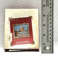 Photo of the decorated box packaging for Hallmark Keepsake Ornament 'Our Friendship' featuring Winnie the Pooh, with a ruler for size reference.