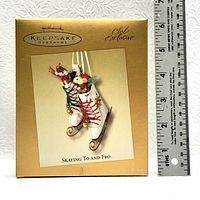 Photo of the original box of Hallmark Keepsake Ornament 'Skating To and Fro' with a ruler for size reference.