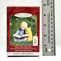 Photo of original box for Hallmark Keepsake Series ornament 'Story Time With Pooh' with ruler showing size approx 2 inches.