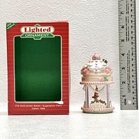 Photo of the lighted ornament placed next to a ruler and its original red and green box with label 'Lighted Ornament The Nutcracker Ballet-Sugarplum Fairy Dated 1986'.