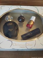 Christian Dior Poison fragrance gift set front packaging showing four items inside including Eau de Toilette bottle, small perfume bottle, lipstick box, and nail polish.