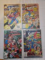Four 'The Adventures of Superman' comic books with colorful covers featuring Superman and other heroes