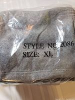 Gray fleece pants folded in plastic with size XL marked on packaging, style no. 2086