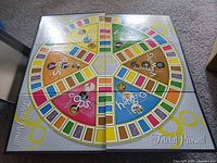 Round colorful 1990s Trivia Pursuit game board with category sections labeled and visual icons.
