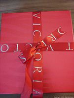 Red gift box wrapped with red Victoria's Secret ribbon tied in a bow.