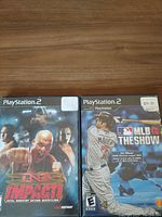 Two PlayStation 2 game cases side by side: TNA Impact and MLB 10 The Show, showing front cover artwork.