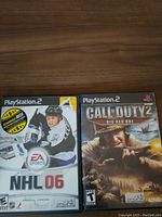 Front cover of NHL 06 and Call of Duty 2 Big Red One PlayStation 2 game cases placed side by side on table.