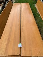 Two solid oak wood planks laid side by side, showing length and width with visible wood grain and some surface wear.