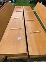 Two solid oak wood planks laid side by side outdoors. Each plank is about 12 feet long and 20 inches wide with three horizontal strips affixed across each plank.