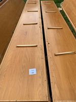 Two long solid oak planks laid out side by side showing the top surface and underside wooden support battens.