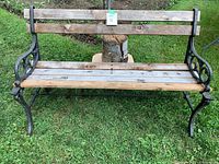 Front view of garden bench showing wooden slats across seat and backrest with cast iron frame.