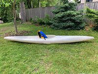 Side profile of the full kayak on grass showing hull shape and overall condition