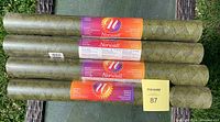 Four rolls of green Norwall vinyl wallpaper arranged parallel on a surface, showing labels and texture.