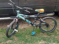 Side view of teal and black Tempest Pro BMX bike with yellow seat and blue pedals, showing overall condition and setup.