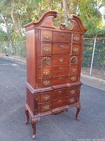 Front left angled view showing the dresser's detailed top, brass handles, and carved legs.