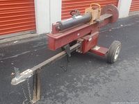 Front and side view of red log splitter showing tow hitch, wheels, horizontal splitting beam