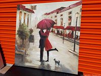Painting of a couple hugging under a red umbrella on a rainy street with a small dog nearby, showing the full artwork and its colors.