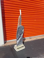 Front and side view of Oreck XL upright vacuum cleaner against orange storage unit doors.