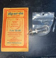 Front view of Mike Stone's Original Dip-er-do stunt plane packaging next to sealed vintage whistle