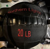 Top view of a black medicine ball showing Northern Lights brand and 20 LB weight marking with stitched panels and some frayed threads.