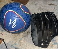 Photo showing a blue Umbro soccer ball with multicolored pattern and a black Nike baseball glove beside it on the floor