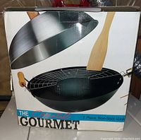 Box showing image of wok set and contents including wooden spatula and tempura rack
