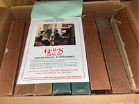 Box containing approximately 40-45 piano playing rolls in original rectangular cardboard boxes along with a Q-R-S catalog for player rolls.
