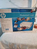 Full box packaging of the HP Photosmart C4480 showing all-in-one printer/scanner/copier and photo printing capabilities