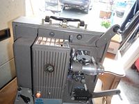 Side view of projector photo-optical data analyzer showing the lens, textured body, hand crank, and power button.