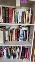 Three shelves of assorted books showing various titles and authors.