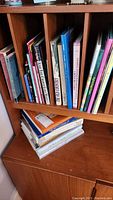 Shelf section showing assorted books of various sizes and colors including titles related to art and general reading.